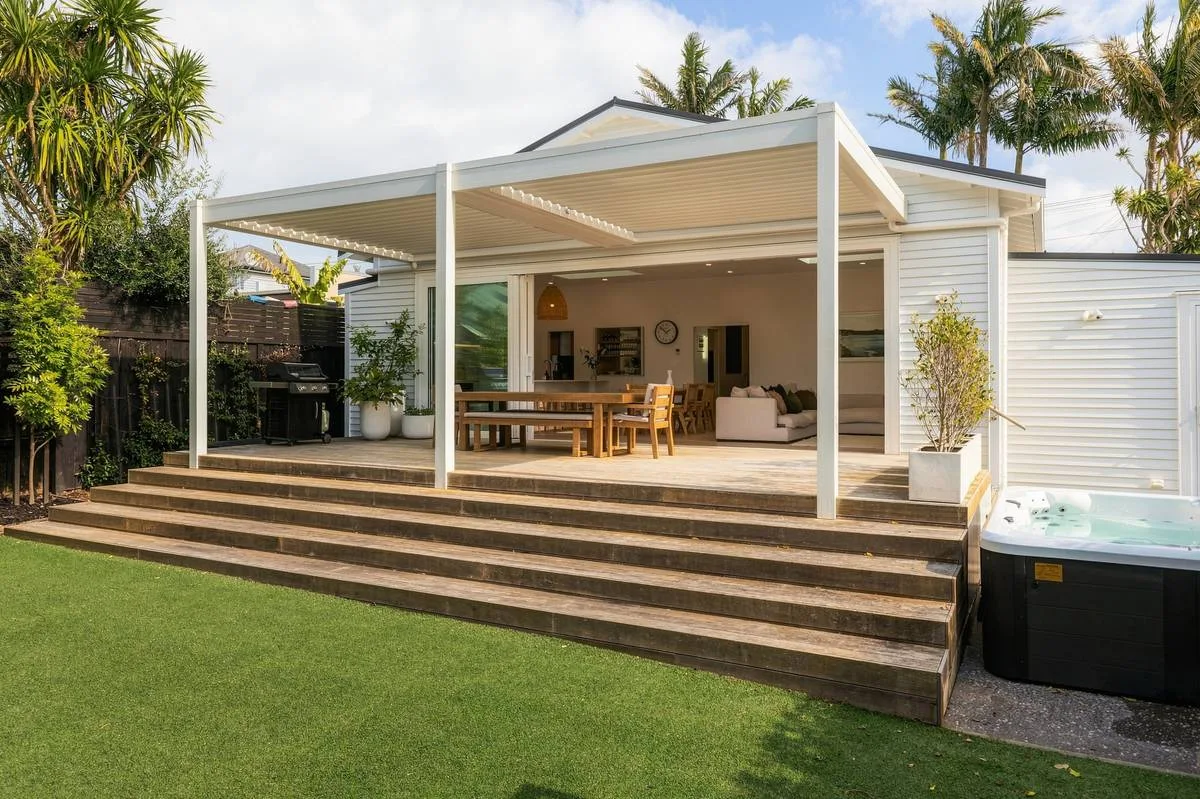 Deck, steps and lawn across the rear elevation of an Auckland home at golden hour